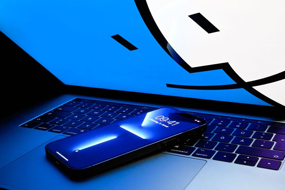 MacBook Proの上に置かれたiPhone 13 Proの写真。iOSシミュレータのイメージ